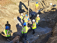 Workers oversee machine work at site.